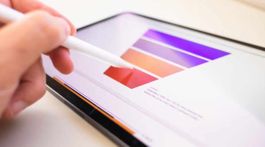 Profissional estruturando funil de vendas com paleta de cores em tablet, representando planejamento estratégico de marketing