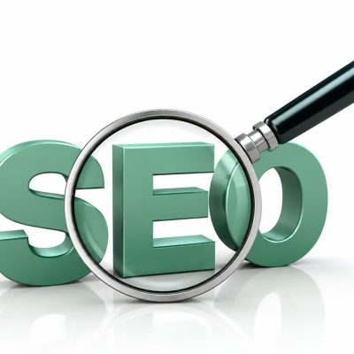 Lupa sobre a sigla SEO representando estratégias de otimização para aumentar o tráfego orgânico do site